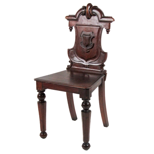 1134 - A Victorian mahogany shield back Hall Chair, with carved back over solid seat on front octagonal tap... 