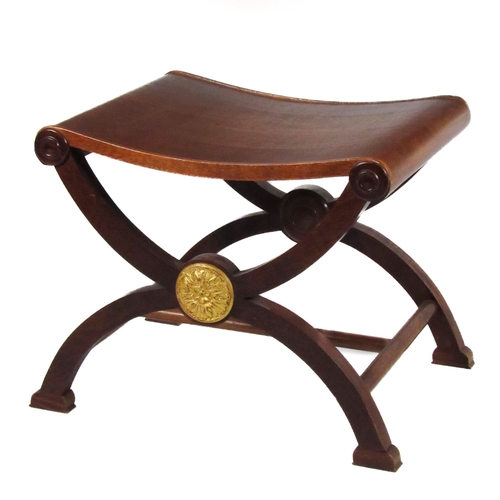 1142 - A Regency style mahogany X framed Window Stool, with shaped seat and circular gilded motifs. (1)Prov... 