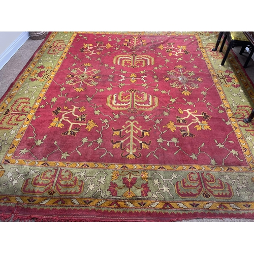 1185 - An attractive Irish woolen Carpet, probably Donegal, the centre claret ground panel with floral and ... 