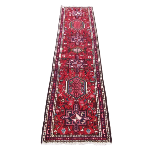 1187 - An antique Middle Eastern (Iranian) woolen Carpet Runner, the central panel with geometric lozenges,... 