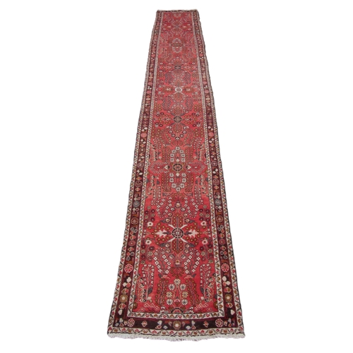 1188 - A semi-antique Middle Eastern woolen Carpet Runner, the burgundy ground multi-floral centre inside a... 