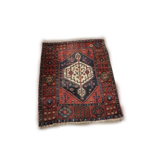 1192 - An antique Middle Eastern Rug, the rectangular central panel on a blue ground with large single meda... 