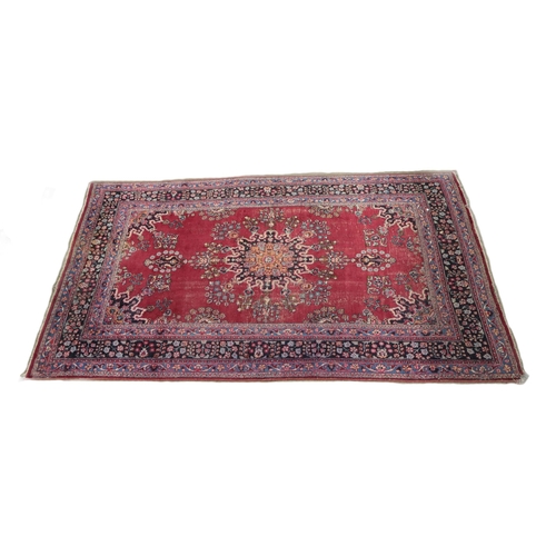 1195 - A large semi-antique Middle Eastern design burgundy ground woolen Carpet, the centre section with st... 