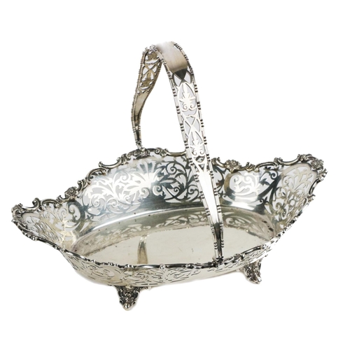 62 - An attractive English silver pierced decorated Fruit Basket, with swing handle on ornate scroll feet... 