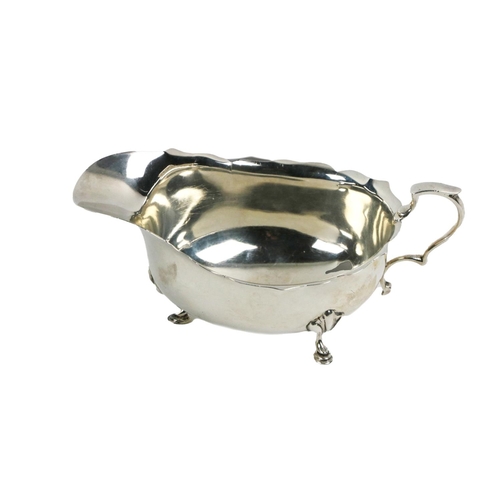 91 - A silver Sauceboat, Birmingham c. 1927, with cut edge border and supported on trifid hoof feet, with... 