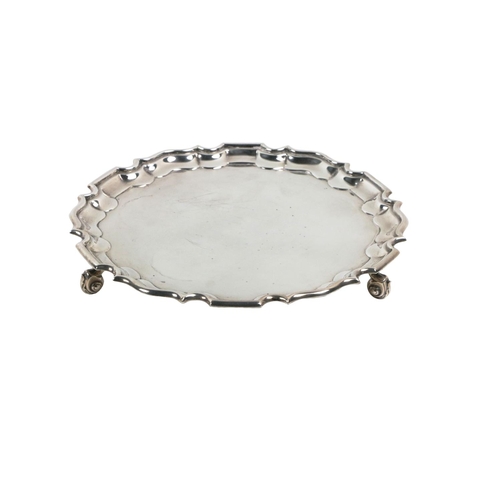 113 - A Sheffield silver circular Salver, c. 1937, with a Chippendale border and supported on three scroll... 