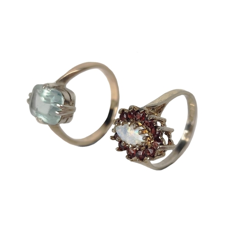 203 - A Ladies silver gilt Ring Set, with central oval opal stone, surrounded by a ruby coloured garnet cl... 