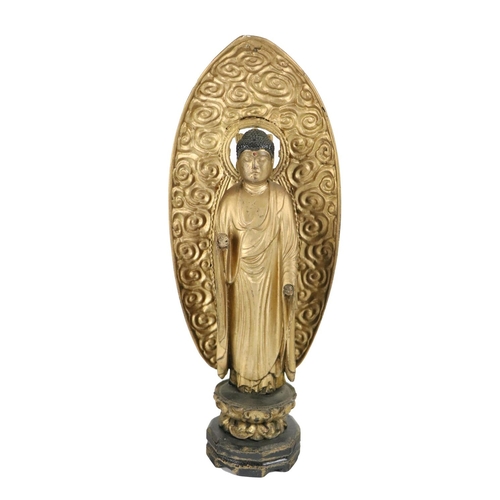 237 - An early Oriental carved wooden gilt highlighted standing Deity, with arched back panel and cloud de... 