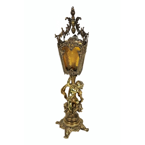 553 - A 19th Century brass Lantern Lamp, with glass and decorative ormolu shade, with cherub support on ci... 