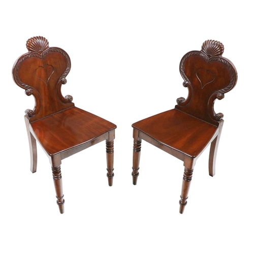 752 - A pair of William IV mahogany Hall Chairs, each with carved shield back, above solid seats on front ... 