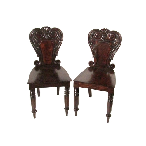 765 - A pair of William IV Irish mahogany Hall Chairs, with carved shield backs over solid seats on front ... 