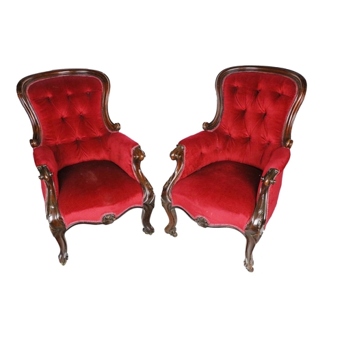 975 - A pair of Irish Victorian mahogany framed Armchairs, covered in deep button back red fabric on front... 