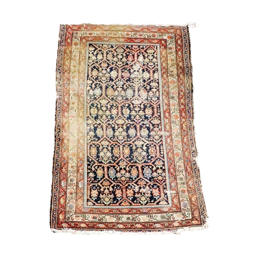 428 - An antique Middle Eastern, possibly Persian woollen Carpet, the navy ground centre with interwoven f... 