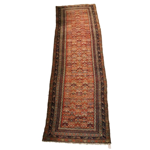 431 - An antique Middle Eastern (possibly Persian) woollen Runner Carpet, the elongated red ground centre ... 