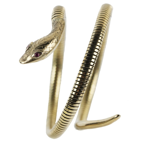 1126 - An attractive 9ct gold double coil 'snake' design Egyptian Revival Bracelet, set with ruby eyes, app... 