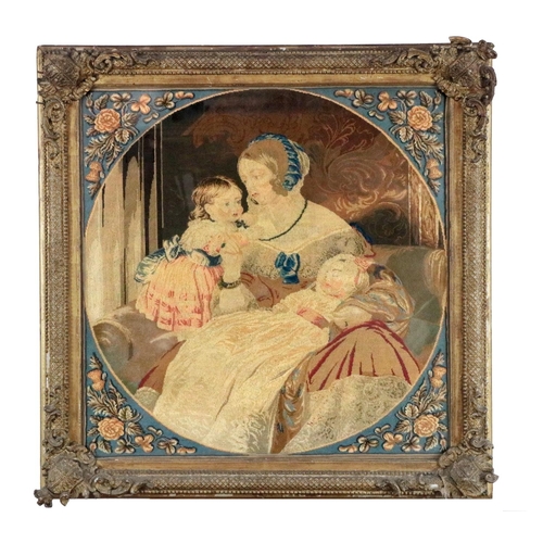 177 - A Victorian Needlework Roundel, depicting a mother holding her two children in ornate gilt frame wit... 