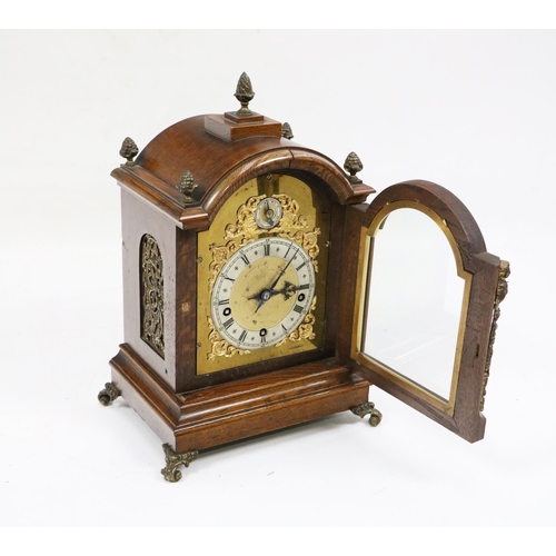 508 - An attractive Edwardian oak cased Mantle Clock, the domed top with multiple brass finials above an a... 