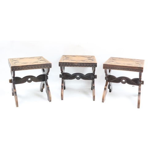 516 - A set of 3 Medieval style carved X framed walnut Stools. (3)