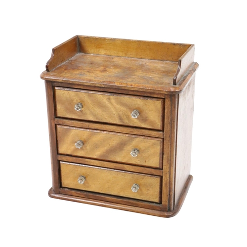 615 - An oak Apprentice Piece design of a three drawer Commode, with shaped gallery back and glass handles... 