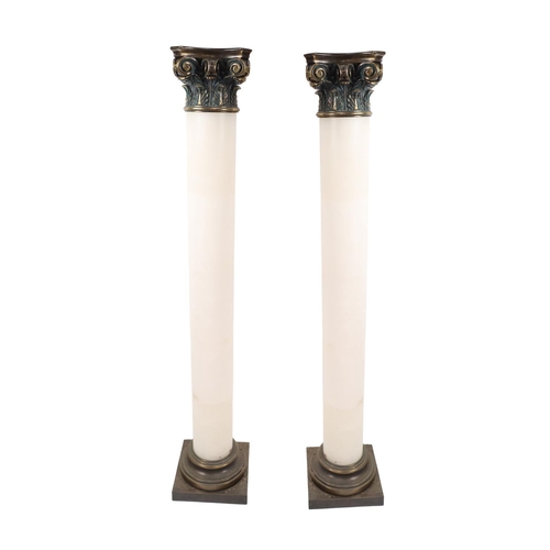 18 - A pair of Corinthian style brass capped alabaster pillar Pedestals, each approx. 160cms high (63