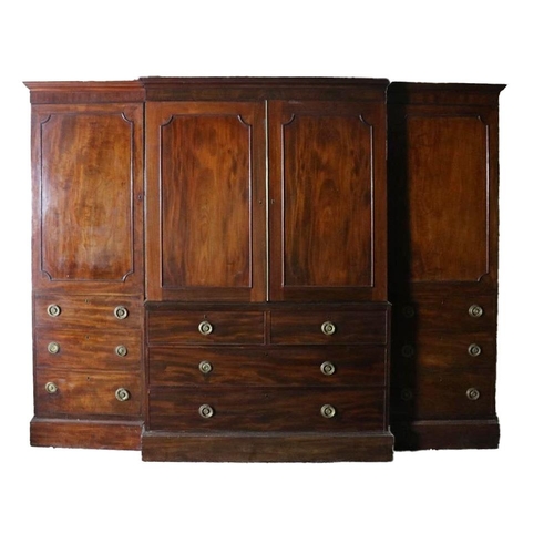 A fine quality Georgian period Irish mahogany breakfront Gentleman's Wardrobe, the moulded cornice over paneled doors, the center section with two short and two long drawers, replicated each side by faux drawers, with ornate circular brass drop handles on plinth base, approx. 203cms high x 252cms w (80" x 99"). (1)