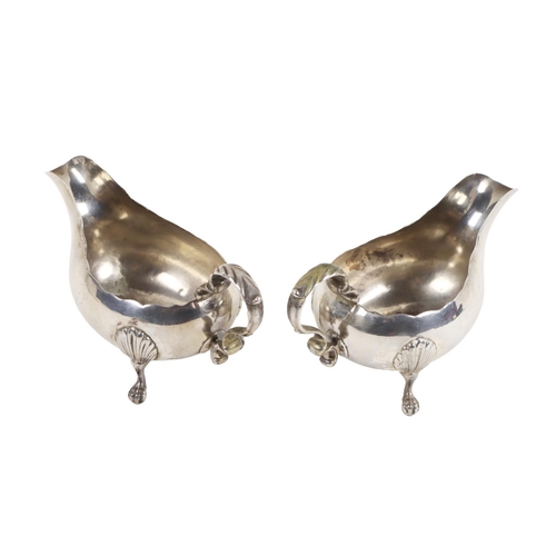 121 - A pair of English silver Victorian period Sauceboats, with scroll handles on ball n' claw leaf cappe... 