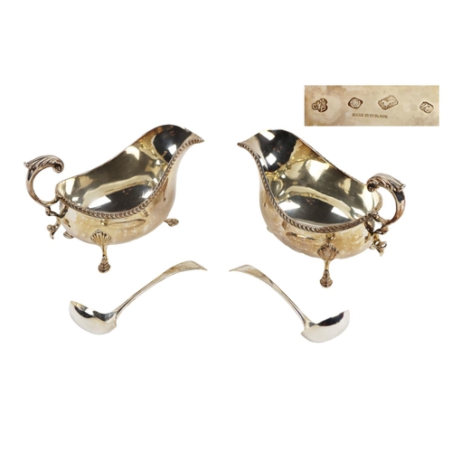 128 - A pair of large Georgian style silver Sauceboats, with gadroon edge, scroll handle, on shell capped ... 