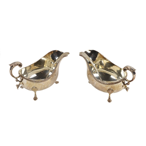 128 - A pair of large Georgian style silver Sauceboats, with gadroon edge, scroll handle, on shell capped ... 