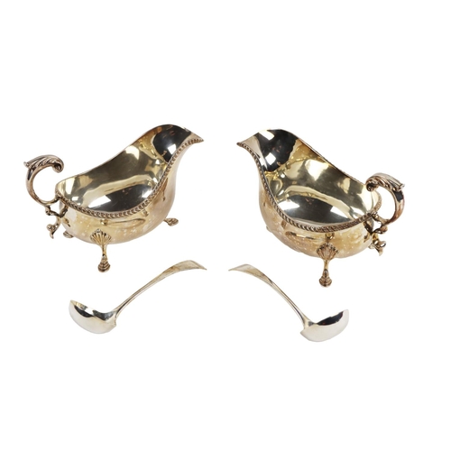 128 - A pair of large Georgian style silver Sauceboats, with gadroon edge, scroll handle, on shell capped ... 