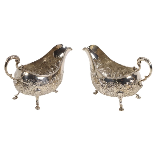 144 - A fine quality pair of 18th Century Irish silver repouss&eacute; floral decorated Sauceboats, each w... 