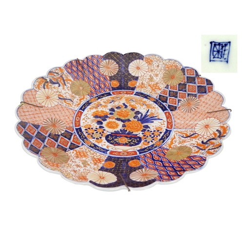 1110 - A large serrated edge circular Imari Platter, with various rust and blue coloured designs and large ... 