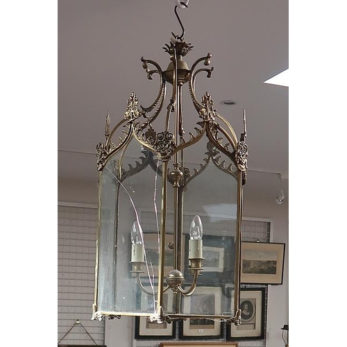 12 - A Regency style brass hexagonal hall lantern, with foliate motifs suspended by in-turned husk ribbed... 