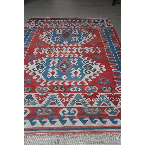 15 - A Kazak wool rug, the cream ground with overall design with multiple rust borders, 200 x 123 cms.