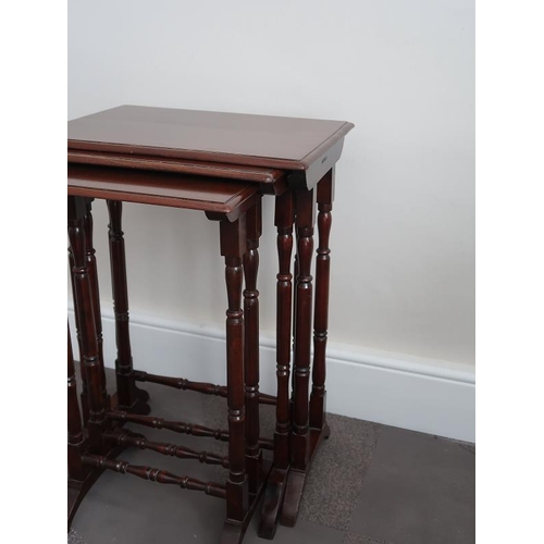 16 - A nest of three mahogany tables, the rectangular tops raised on turned supports and splayed feet, 50... 