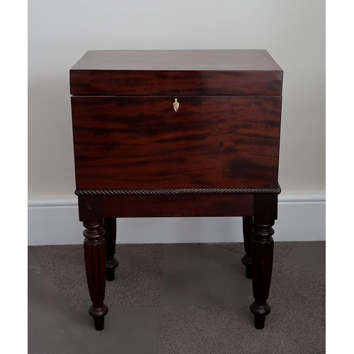 28 - A George IV mahogany cellarette, with fitted interior on fluted legs and brass castors, 70 cms high,... 