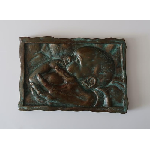 57 - 20th Century Continental School 'A baby in a mother's arm'. Bronze Plaque, 24 cms high, 35 cms long.