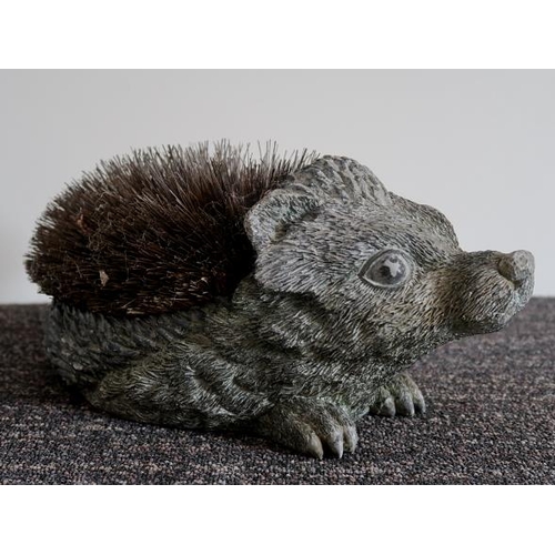 59 - An early 20th century painted plaster model of a hedgehog, 34 cms long, 17 cms high.