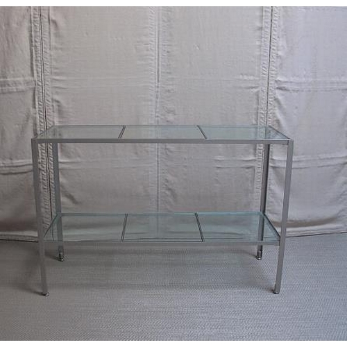 7 - A mid century chrome and plate glass two tier consul table on angular supports, 77 cms high, 114 cms... 