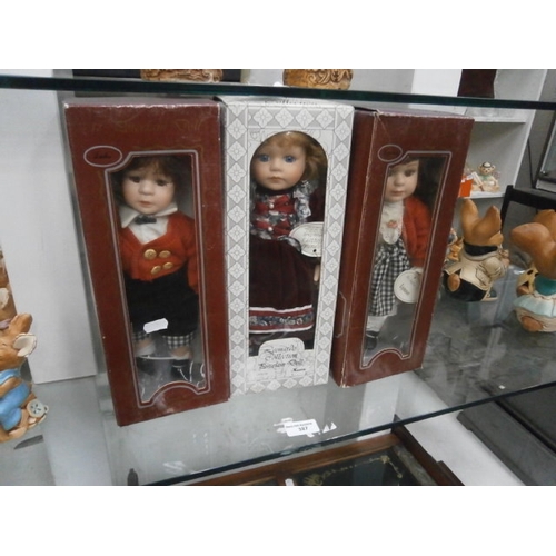 387 - Three boxed porcelain dolls