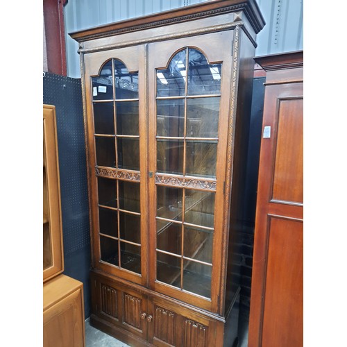 709 - Tall oak bookcase on double cupboard base with 4 glass shelves