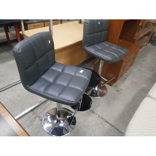 679 - Pair of chrome based padded bar stools and a small black glass table