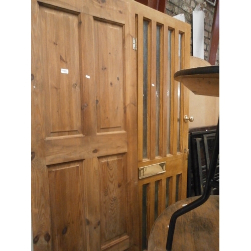 677 - A pine panelled door and a glass panelled front door with fittings