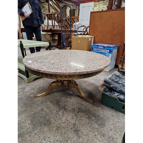 705 - A large circular coffee table with composite top on ornate gilt metal base