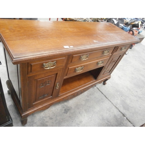 671 - A large antique carved 5 drawer sideboard with ornate brass handles