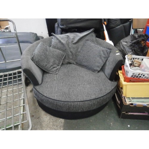 691 - An upholstered circular swivel armchair with cushions