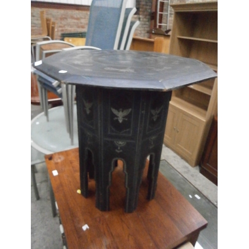 629 - A small octagonal ebonised table with detailed decoration