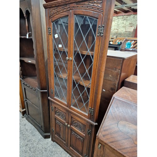 616 - A vintage carved oak corner cabinet with lead glazed doors