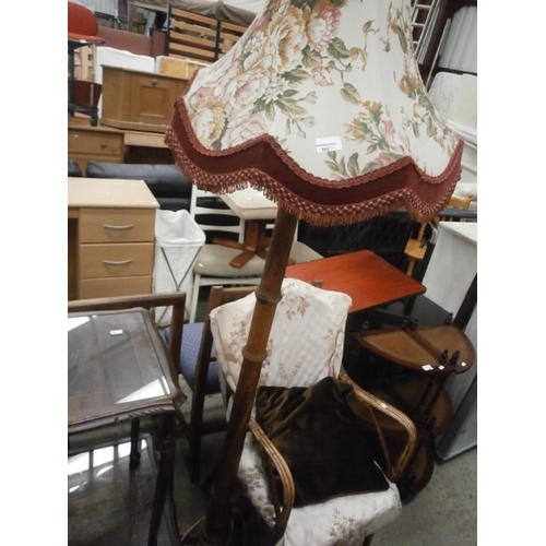 665 - A vintage standard lamp with shade and a cane framed chair