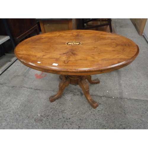 621 - A vintage Burr Walnut tilt top breakfast table with inlaid decoration and ornately carved pedestal