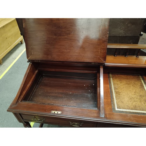 705 - A small vintage mahogany leather topped desk with lift top writing slope and side drawer and cupboar... 